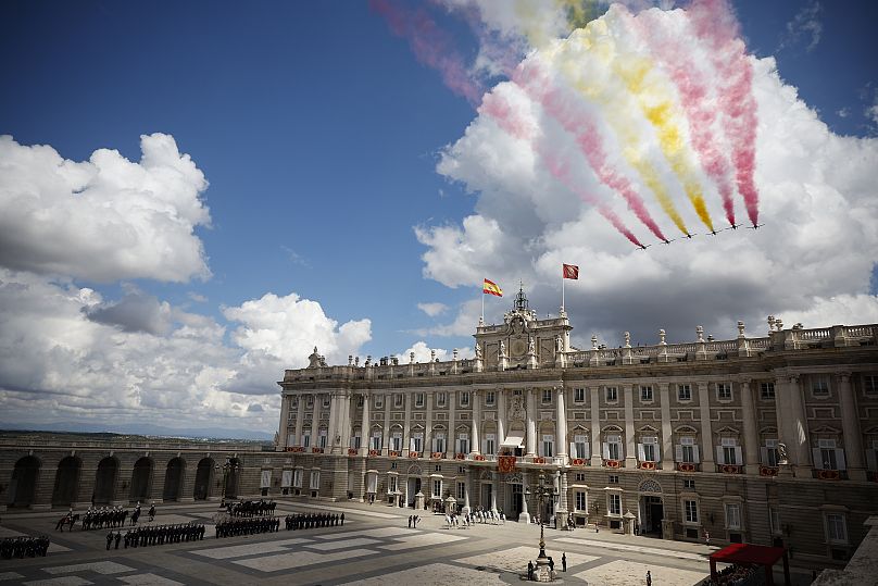 The Spanish Airforce "Patrulla Aguila" (Eagle Patrol) aerobatic team flies over the Royal Palace during commemorations