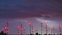 Villámok világítják meg az éjszakai égboltot az Odervorland szélerőműpark felett a kelet-brandenburgi Oder-Spree körzetben, Németországban, 2024. június 18-án