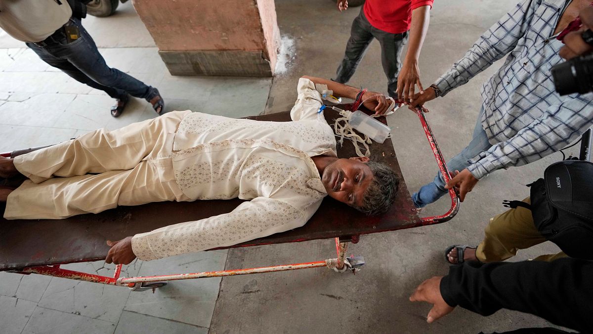 رجل يُنقل للعلاج إلى مستشفى مدني بعد أن مرض إثر تناوله مشروبات كحولية مغشوشة في أحمد آباد، الهند، 2022. صورة أرشيفية.