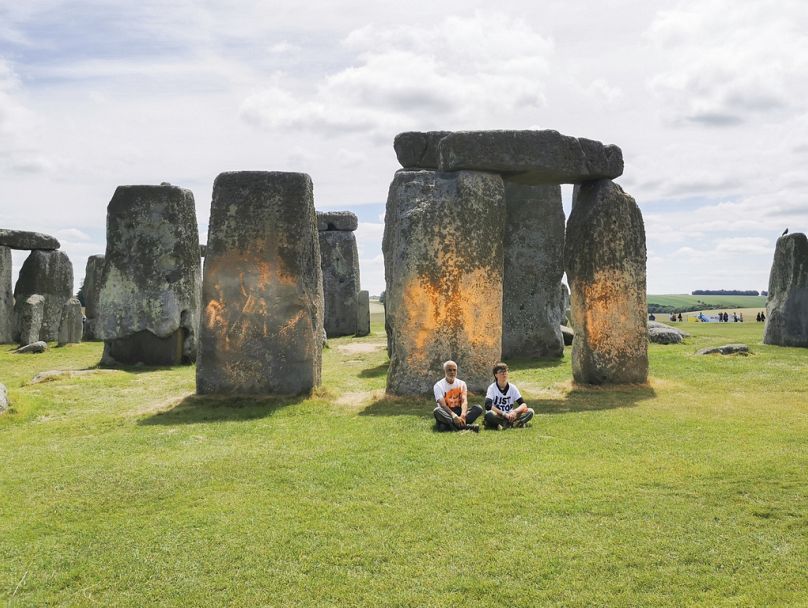 Just Stop Oil activists cover the historic Stonehenge site in southwest England with orange-coloured cornflour.