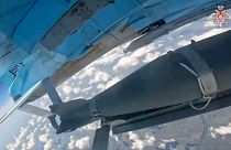 На этом снимке из недатированной видеозаписи, опубликованной Минобороны РФ, видно, как самолёт ВВС России выпускает управляемую бомбу.