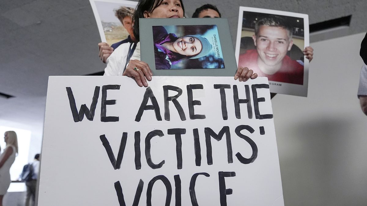 Family members of victims of Boeing plane crashes display signs after the Senate hearing