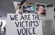 Family members of victims of Boeing plane crashes display signs after the Senate hearing