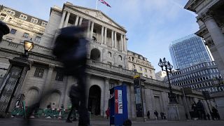 People walk past the Bank of England in London