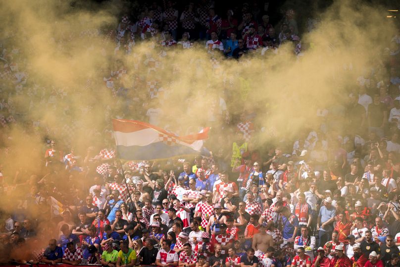 Croatian supporters in Hamburg light a flare as they cheer during a Group B match between Croatia and Albania at the Euro 2024 football tournament, 19 June 2024