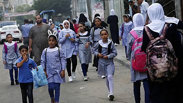 طلاب يسيرون إلى المدرسة الابتدائية في مخيم الشاطئ للاجئين في مدينة غزة