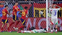 Spanyol játékosok (pirosban) örülnek az olasz Riccardo Calafiori (a földön) öngóljának a spanyol - olasz Eb-mérkőzésen a gelsenkircheni AufSchalke Arénában 2024. 06.20-án.