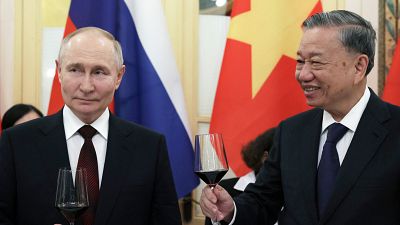 Russian President Vladimir Putin and Vietnamese President To Lam toast during a gala reception.