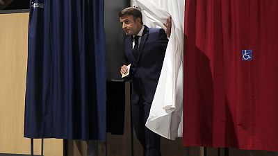 French President Emmanuel Macron leaves the voting booth in Le Touquet, northern France, 19 June 2022