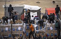 I palestinesi saccheggiano un camion di aiuti umanitari mentre attraversava la Striscia di Gaza a Rafah, domenica 17 dicembre 2023.