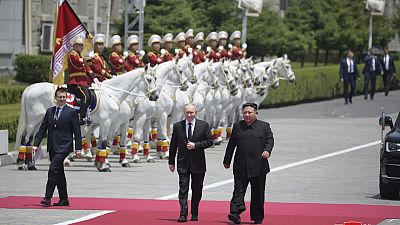 Russian President Vladimir Putin and North Korea's leader Kim Jong Un walk together during the official welcome ceremony at the Kim Il Sung Square