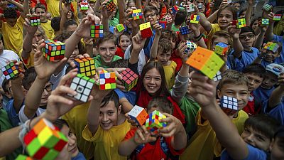 Kinder halten einen Rubik's Cube.