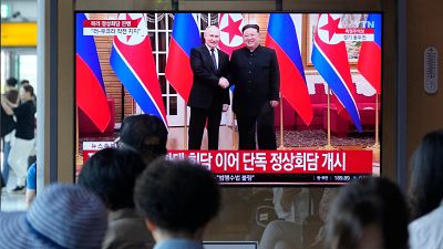 A TV screen shows an image of North Korean leader Kim Jong Un, right, and Russian President Vladimir Putin during a news program, at the Seoul Railway Station, June 19, 2024