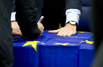 Eurogroup finance ministers sign an EU flag during a round table meeting of eurogroup finance ministers in Luxembourg, Monday, Oct. 9, 2017. 
