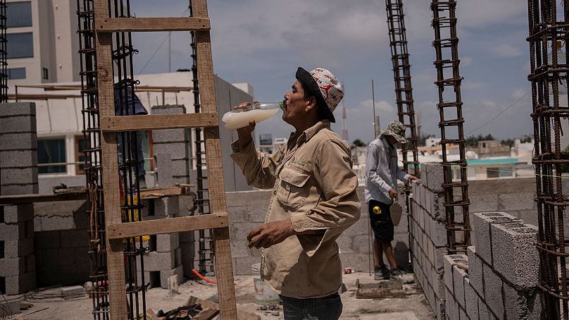 Jorge Moreno, un trabajador, bebe agua con sabor para hacer frente a la ola de calor durante su jornada laboral en una obra en Veracruz, México, el 17 de junio de 2024. 