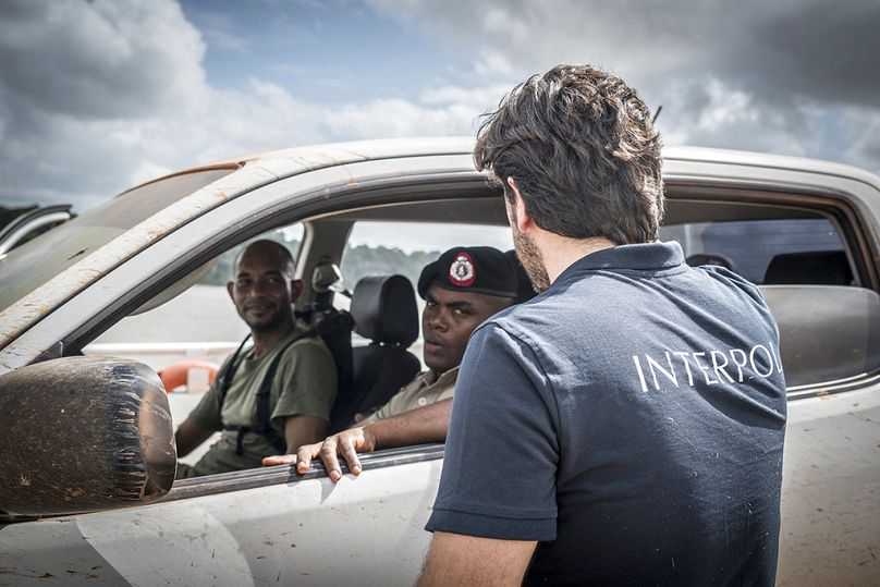 Interpol officer talking with Guyana police officers near a goldmine in the Mazaruni region, 4 April 2018