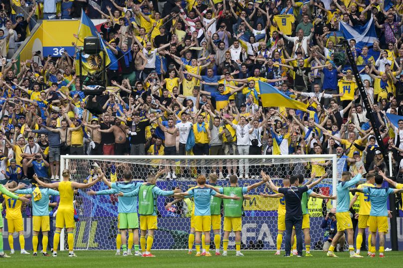 The Ukrainian team and their fans celebrate the nation's first victory at Euro 2024 against Slovakia