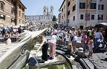 يصطف الناس عند النافورة لإنعاش أنفسهم في يوم حار في ساحة Piazza di Spagna في روما
