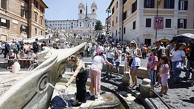 يصطف الناس عند النافورة لإنعاش أنفسهم في يوم حار في ساحة Piazza di Spagna في روما