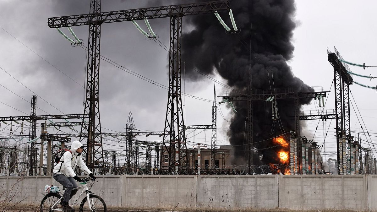 گذر یک دوچرخه سوار در مارس ۲۰۲۴ از کنار تاسیسات برق در خارکیف که مورد حمله هوایی روسیه قرار گرفت 