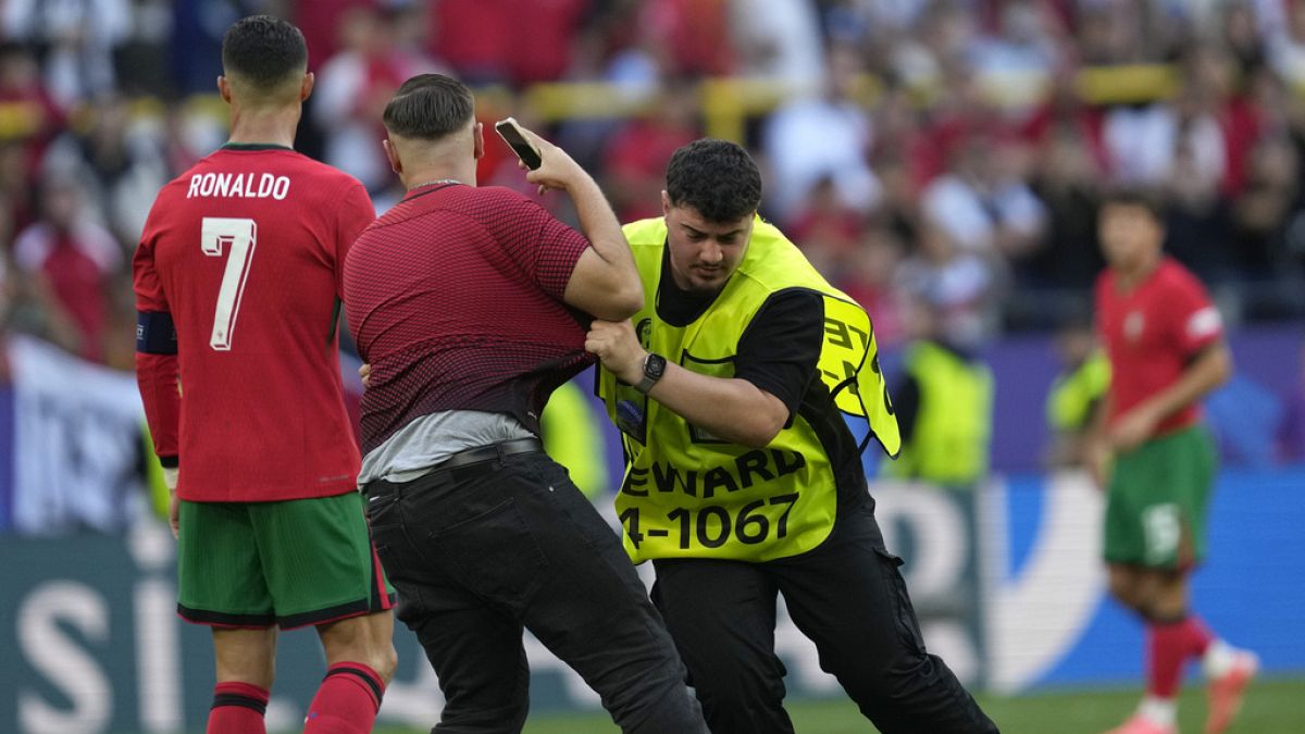 Steward catches a pitch invader that ran to Portugal's Cristiano Ronaldo during a Group F match between Turkey and Portugal at the Euro 2024 soccer tournament in Dortmund.