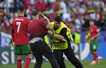 Steward catches a pitch invader that ran to Portugal's Cristiano Ronaldo during a Group F match between Turkey and Portugal at the Euro 2024 soccer tournament in Dortmund.