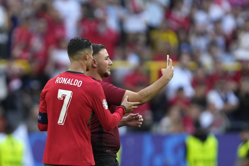 A pitch invader takes a selfie with Portugal's Cristiano Ronaldo during a Group F match between Turkey and Portugal at the Euro 2024 soccer tournament in Dortmund, Germany.