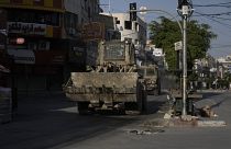 جرافة إسرائيلية ومركبة مدرعة تتحركان في أحد الشوارع خلال مداهمة في مدينة جنين بالضفة الغربية، الخميس 6 يونيو 2024.