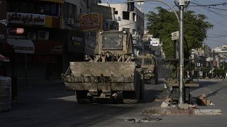جرافة إسرائيلية ومركبة مدرعة تتحركان في أحد الشوارع خلال مداهمة في مدينة جنين بالضفة الغربية، الخميس 6 يونيو 2024.