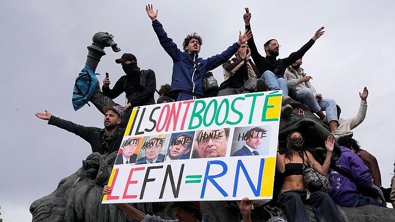 یک معترض فرانسوی با یک بنر ضد راست افراطی در دست که چهره روسای جمهور فرانسه و کلمه «هونته» یا «شرم» را در جریان تظاهرات پاریس به تاریخ ۱۵ ژوئن ۲۰۲۴ نشان می دهد.