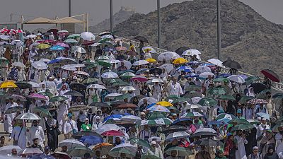 Peregrinos muçulmanos usam guarda-chuvas para se protegerem do sol no apedrejamento simbólico do diabo, o último rito do Hajj anual, em Mina, 18 de junho 2024