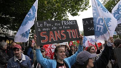 Una manifestante tiene un cartello contro l'estrema destra con la scritta "Le Pen, la mia Francia avverrà senza di te" durante una manifestazione a Parigi, il 15 giugno 2024