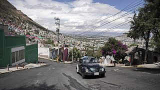 A 1996 Volkswagen Beetle is drivn up a steep hill in the Cuautepec neighborhood of Mexico City