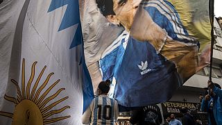 TIfosa Argentina con bandiera raffigurante Diego Armando Maradona