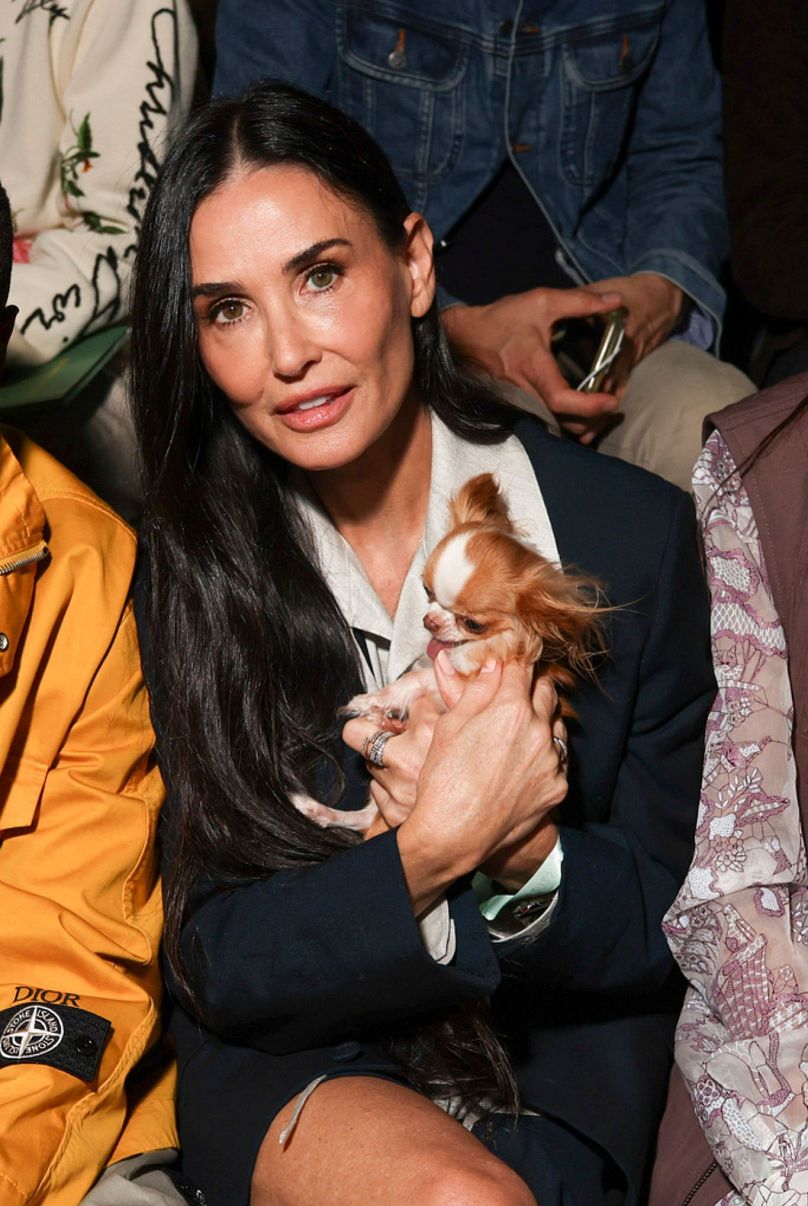 Demi Moore poses with a dog at the Dior Spring Summer 2025 collection in Paris. 