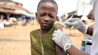 A health worker administers a cervical cancer vaccine HPV Gardasil to a girl on the street in Ibadan, Nigeria.