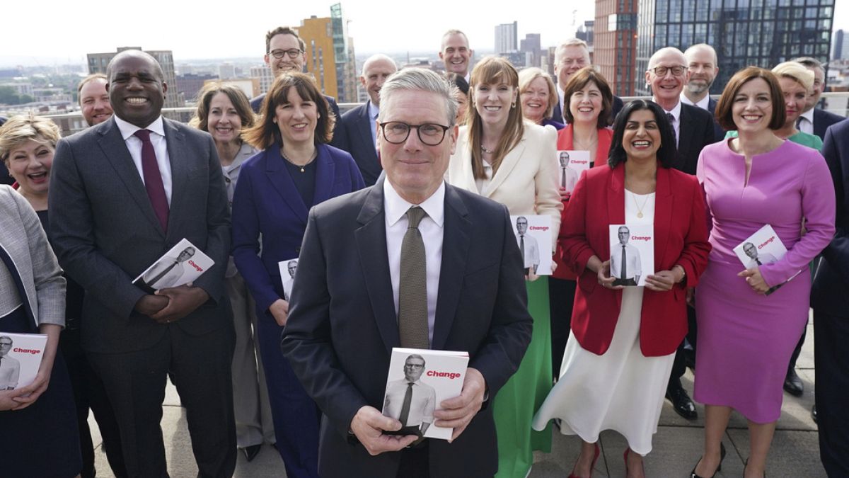 Britain's Labour Party leader Keir Starmer poses for a photo with key party members, at Co-op HQ in Manchester, England, Thursday, June 13, 2024.