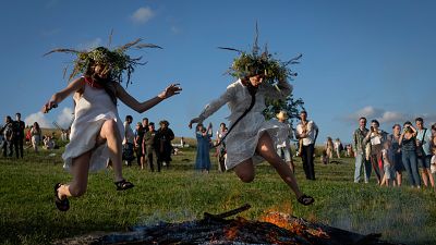 Ουκρανές γυναίκες πηδούν πάνω από τη φωτιά σε μια παραδοσιακή γιορτή για το θερινό ηλιοστάσιο κοντά στην πρωτεύουσα Κίεβο. Κυριακή 23 Ιουνίου 2024. 