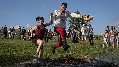 A couple jumps over the fire at a traditional Midsummer Night celebration near capital Kyiv, Ukraine.