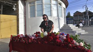 Женщина возлагает цветы к импровизированному мемориалу перед Свято-Успенским собором после нападения в Махачкале, республика Дагестан, 24 июня 2024 г.
