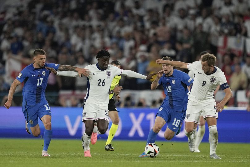 England's Harry Kane, left, runs with the ball ahead Slovenia's Benjamin Sesko during a Group C match between the England and Slovenia at Euro 2024 
