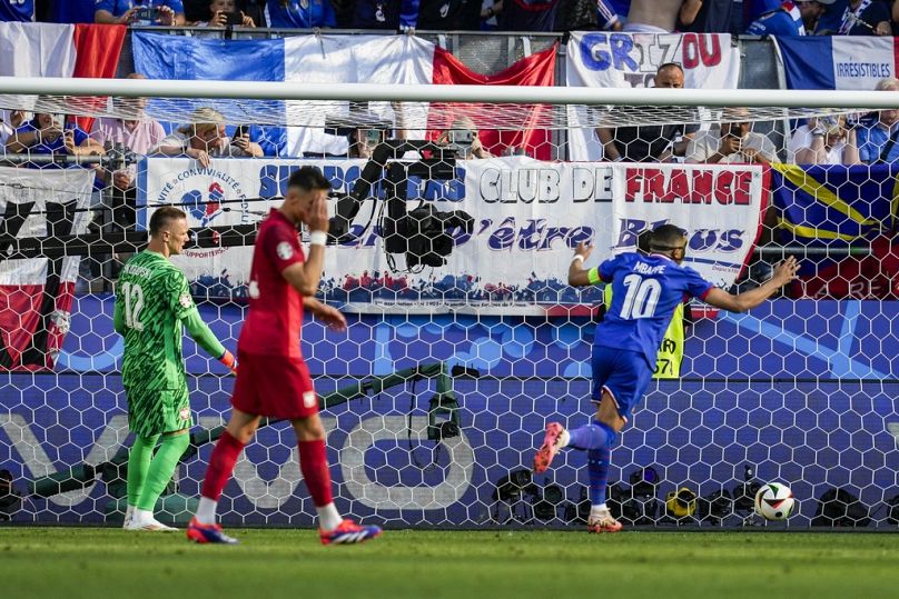 Kylian Mbappe of France, centre, scores a penalty kick during a Group D match between the France and Poland at the Euro 2024