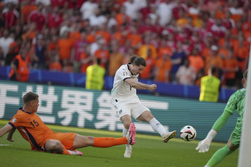 Austria's Marcel Sabitzer, center, scores a goal past Micky van de Ven of the Netherlands (15) during a Group D match at Euro 2024 