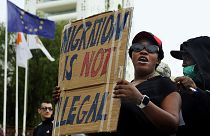 A person holds a placard during a protest against new government policies on migration, at Elephteria square in Nicosia, 20 April 2024