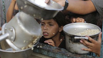 صبي فلسطيني يشاهد حصته من المساعدات الغذائية قبل عطلة عيد الأضحى المقبلة في خان يونس