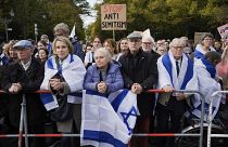 Berlin'de antisemitizm karşıtı bir gösteri sırasında insanlar konuşmaları dinliyor.
