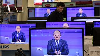 Russian President Vladimir Putin is seen on television screens in a shop in Moscow, 25 April 2013