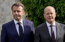 El canciller alemán, Olaf Scholz, y el presidente francés, Emmanuel Macron, pasean por el jardín de Meseberg, Alemania, el 28 de mayo de 2024.