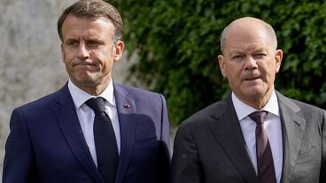 German Chancellor Olaf Scholz and French President Emmanuel Macron walk through the garden in Meseberg, Germany on May 28, 2024.