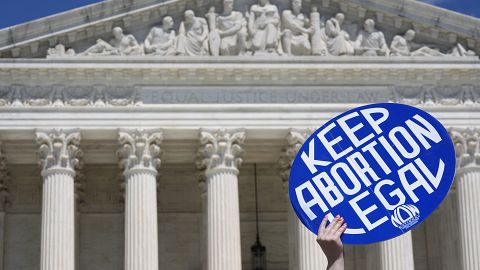 A person holds up a sign as abortion rights activists and Women's March leaders protest as part of a national day of strike actions outside the Supreme Court